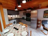 a kitchen with a table and a kitchen with a refrigerator at Appartement Le Grand-Bornand, 3 pièces, 6 personnes - FR-1-241-61 in Le Grand-Bornand