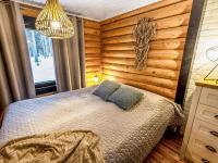 a bedroom with a bed in a room with wooden walls at Holiday Home Tiira by Interhome in Himahuuha