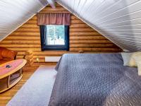 a bedroom with a bed in a wooden cabin at Holiday Home Tiira by Interhome in Himahuuha