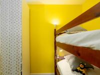 a bedroom with two bunk beds with yellow walls at Studio East Land-3 by Interhome in La Grande Motte