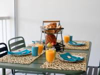 a table with a teddy bear in a basket and orange juice at Studio East Land-3 by Interhome in La Grande Motte