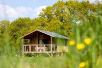 a small house with a porch in a field of grass at Dihan Evasion in Ploemel