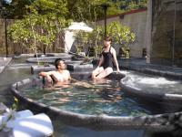a man and a woman sitting in a hot tub at Onsen Papawaqa in Tai&#39;an