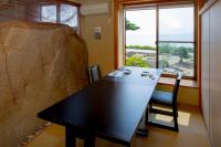 a black table and chair in a room with a window at Sennenmatsu in Imabari