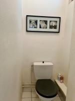 a bathroom with a toilet with a green seat and a picture at Bienvenue in Montrouge
