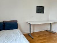 a table and a bed in a room with a desk at Bienvenue in Montrouge