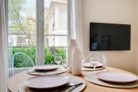 a table with plates and wine glasses and a window at Comfy Suite by Les Maisons de Charloc Homes in Boulogne-Billancourt