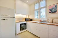 a white kitchen with a refrigerator and a sink at Comfy Suite by Les Maisons de Charloc Homes in Boulogne-Billancourt