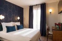 a hotel room with a large bed with blue pillows at Bijou Hôtel Paris Boulogne in Boulogne-Billancourt