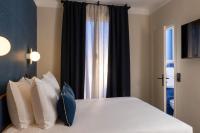 a bedroom with a bed with pillows and a window at Bijou Hôtel Paris Boulogne in Boulogne-Billancourt