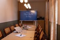 a dining room with a table and a tv at Bijou Hôtel Paris Boulogne in Boulogne-Billancourt