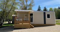 a tiny house with a porch and a roof at Camping Porte des Vosges in Bulgnéville