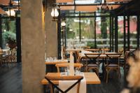 a restaurant with wooden tables and chairs and windows at Hotel Bernarda in Varaždinske Toplice