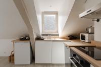 a kitchen with white cabinets and a window at Studio et appartements Sainte Catherine in Honfleur