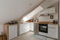 a kitchen with white cabinets and a staircase with an attic at Studio et appartements Sainte Catherine in Honfleur