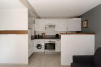 a kitchen with white cabinets and a washing machine at Studio et appartements Sainte Catherine in Honfleur