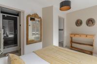 a bedroom with a bed and a mirror on the wall at Studio et appartements Sainte Catherine in Honfleur