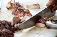 een persoon die een stuk voedsel snijdt met een mes bij El Encanto Hotel Boutique in Duitama