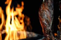 Een close-up van een stuk vlees naast een vuur. bij El Encanto Hotel Boutique in Duitama