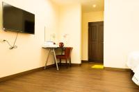 a room with a table and a television on the wall at Lin Tea B&amp;B in Ruisui