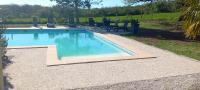 - une piscine d&#39;eau bleue dans la cour dans l&#39;établissement La Petite Grange, à Saint-Martin-Labouval