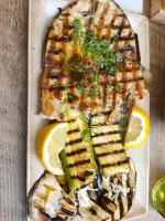 een vis in een doos met schijfjes citroen bij OPERAPRIMASUITE in Messina