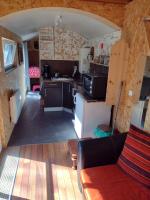 a small kitchen in a tiny house with a couch at En attendant que ça pousse avec bain nordique privatif in Theix