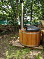 a wooden tub sitting in the grass in a yard at En attendant que ça pousse avec bain nordique privatif in Theix