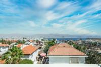 Blick auf eine Stadt mit Gebäuden und das Meer in der Unterkunft Villa Li Eilat in Eilat