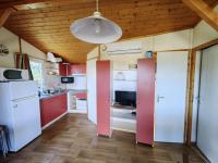 a kitchen with red cabinets and a white refrigerator at Chalet Agde, 3 pièces, 6 personnes - FR-1-607-59 in Agde