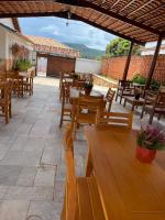 een patio met houten tafels en houten stoelen bij Pousada Solar Mestre Propício in Pirenópolis