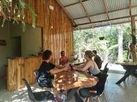un grupo de personas sentadas en una mesa en un restaurante en El Gecko Hotel & Tours, en Paquera