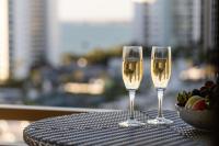 two glasses of white wine on a table with a bowl of fruit at The Ritz-Carlton, Sarasota in Sarasota