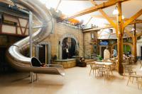 a restaurant with a slide in the middle of a room at Camping Fuussekaul in Heiderscheid