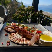 a plate of food with a sausage and other foods at Hotel Aross in Vlorë
