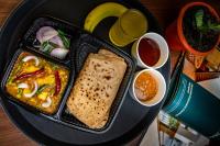 a black plate of food with a sandwich and dipping sauce at Muscatel Nirvana – At The Mall Road in Darjeeling