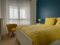 a bedroom with a large bed with a yellow blanket at Bel appartement avec vue sur la Baie d&#39;Authie in Berck-sur-Mer
