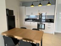 a kitchen with a wooden table and white cabinets at Bel appartement avec vue sur la Baie d&#39;Authie in Berck-sur-Mer