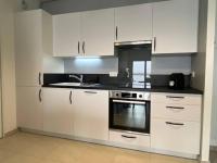 a kitchen with white cabinets and a stove at Bel appartement avec vue sur la Baie d&#39;Authie in Berck-sur-Mer