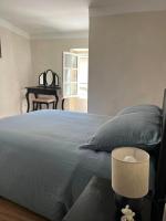 a bedroom with a blue bed and a table at Maison de village in Lédenon