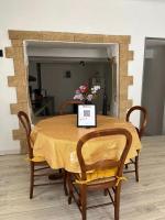 a dining room table with a yellow table cloth on it at Maison de village in Lédenon