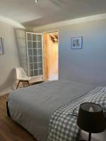 a bedroom with a bed and a chair and a window at Maison de village in Lédenon