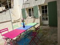 a colorful table and chairs in front of a building at Maison de village in Lédenon