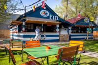 a man standing in front of a building with a table and chairs at DunaVera Apartman in Budapest
