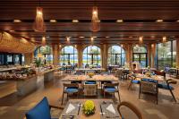 a restaurant with tables and chairs and windows at Wyndham Hoi An Royal Beachfront Resort & Villas in Hoi An