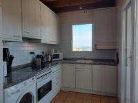 a kitchen with white cabinets and a sink and a window at Appartement Urrugne, 3 pièces, 6 personnes - FR-1-239-772 in Urrugne
