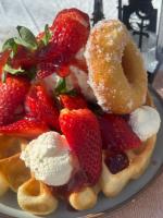 um prato de waffles com morangos e sorvete em Gryts Skägårdscafe & Restaurang em Gryt