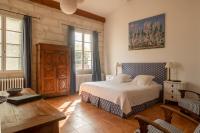 a bedroom with a bed and a table and windows at HOTEL et APPARTEMENTS DOMAINE DES CLOS - Teritoria in Beaucaire