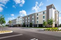 un gran edificio en una calle con aparcamiento en WoodSpring Suites Port St Lucie, en Port Saint Lucie