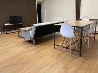 - une table et des chaises dans une chambre dotée de parquet dans l&#39;établissement Appartements Baron Bouvier, à Vesoul